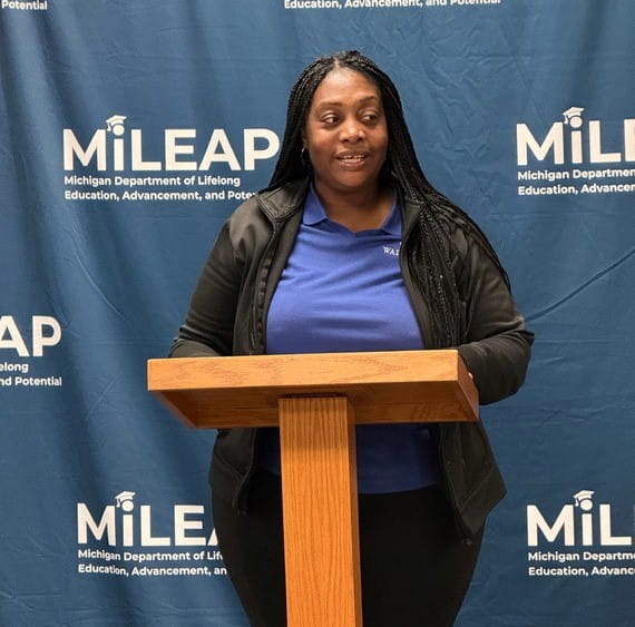 An adult speaking at a podium