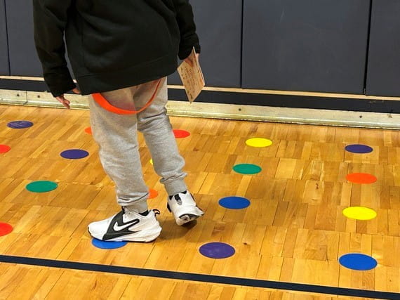A student participates in the Human Mastermind challenge, working to identify the correct pattern to "crack the code."