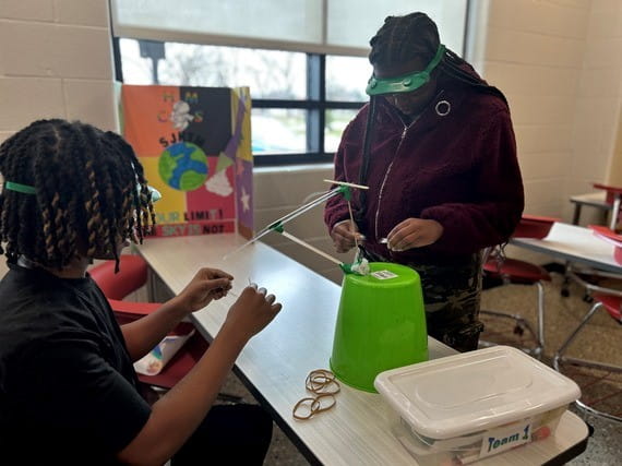 Students demonstrate crane experiment for NASA STEM challenge.