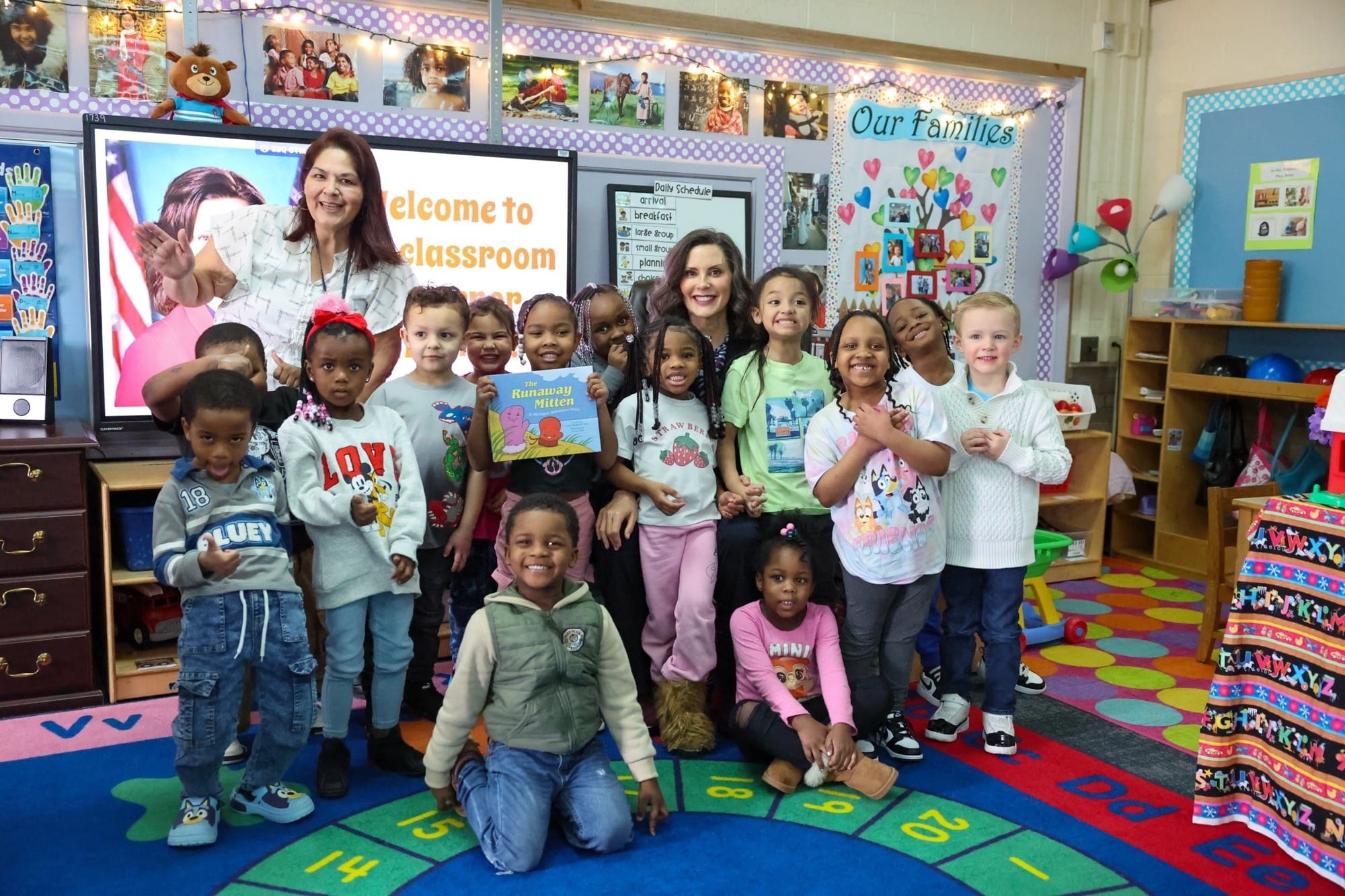 Gov. Whitmer sits on the carpet with students in a preschool classroom at Henry Doerr Early Childhood Center in Saginaw