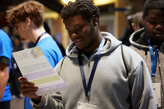 A student reviews a pamphlet to learn more about MiLEAP tuition-free programs.