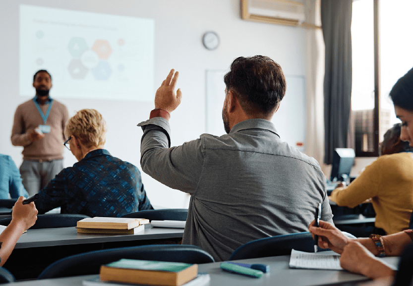 Student in classroom with raised hand