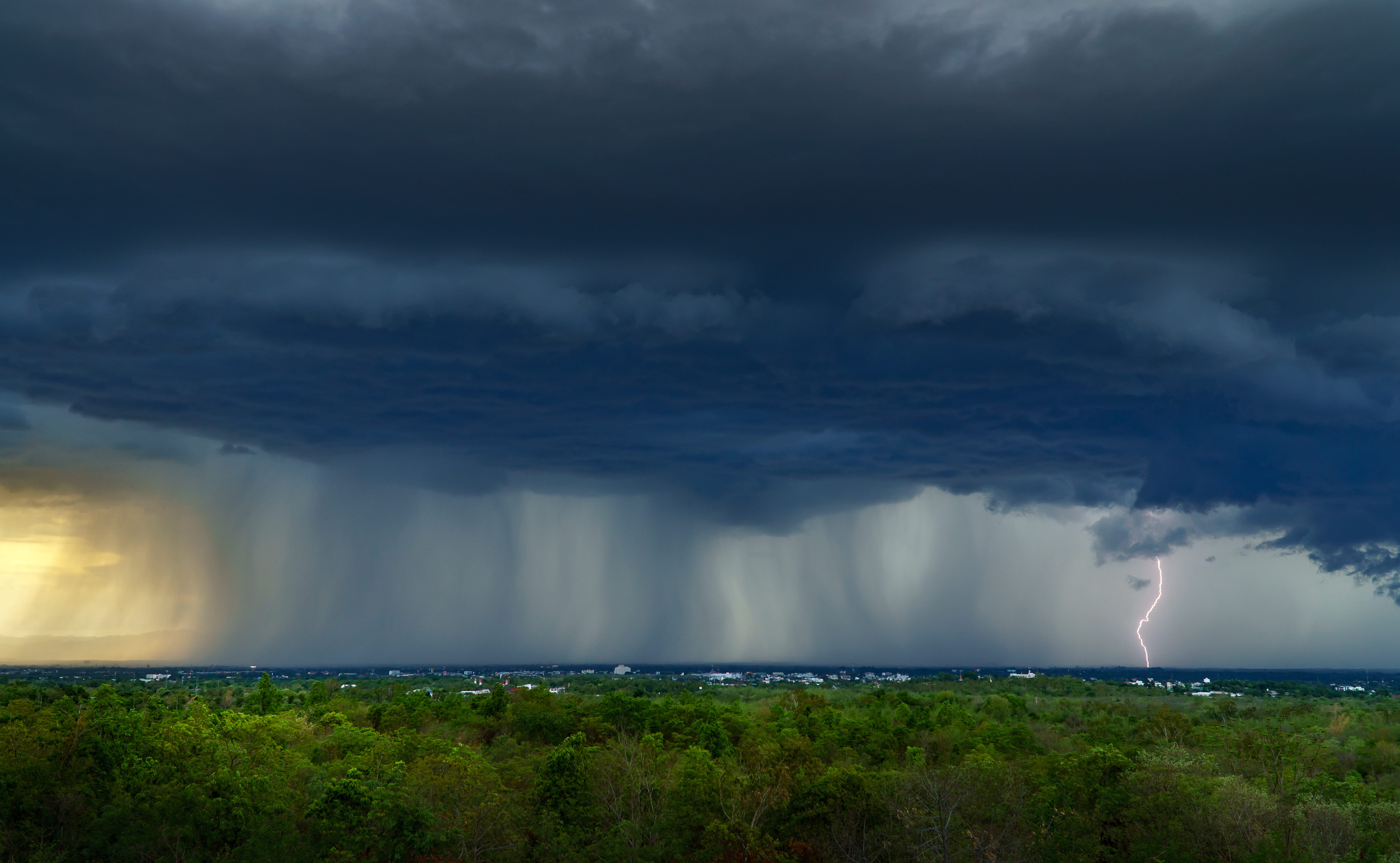 Dark clouds, rain and lightning viewed from a distance