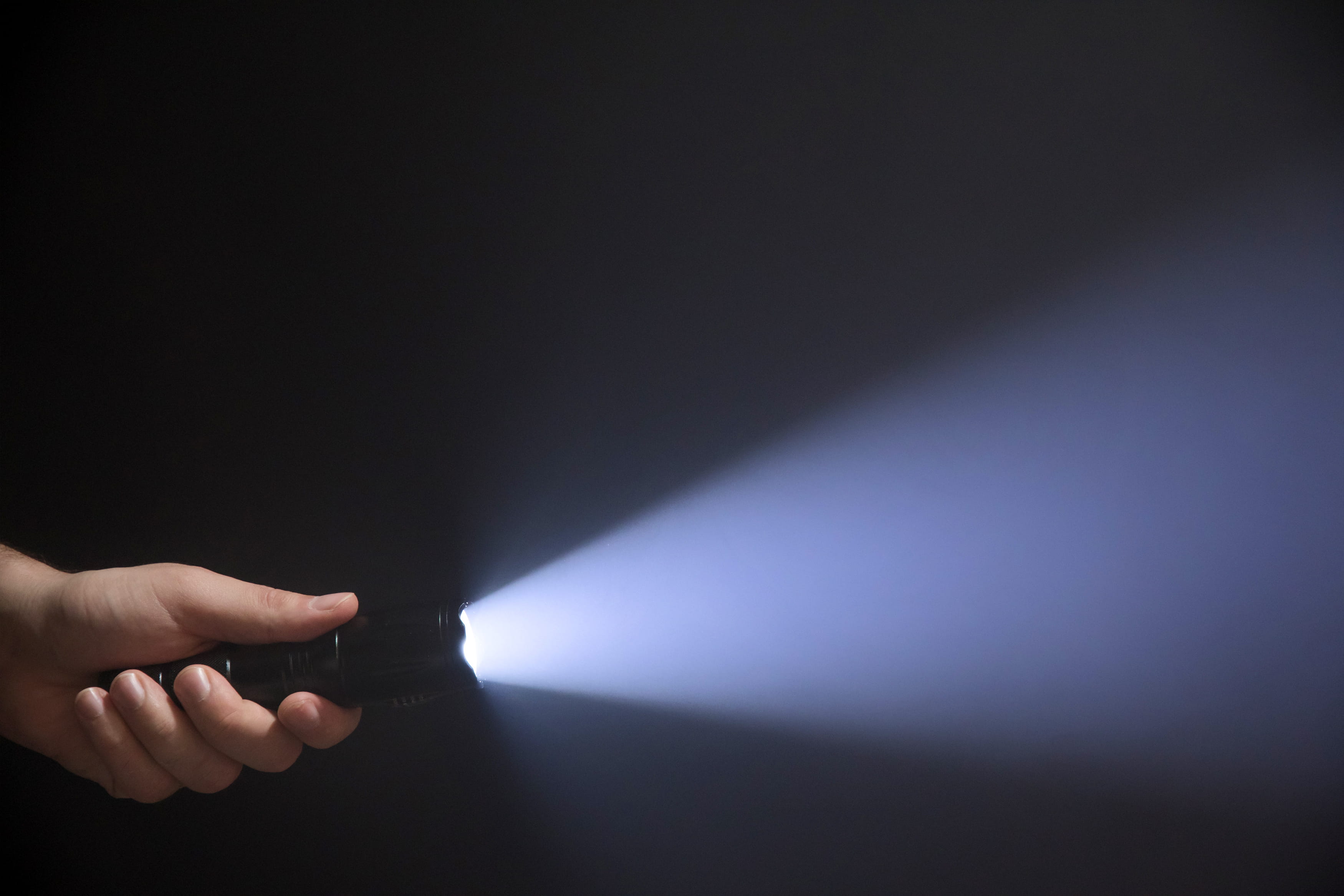 And hand holding a flashlight in the dark