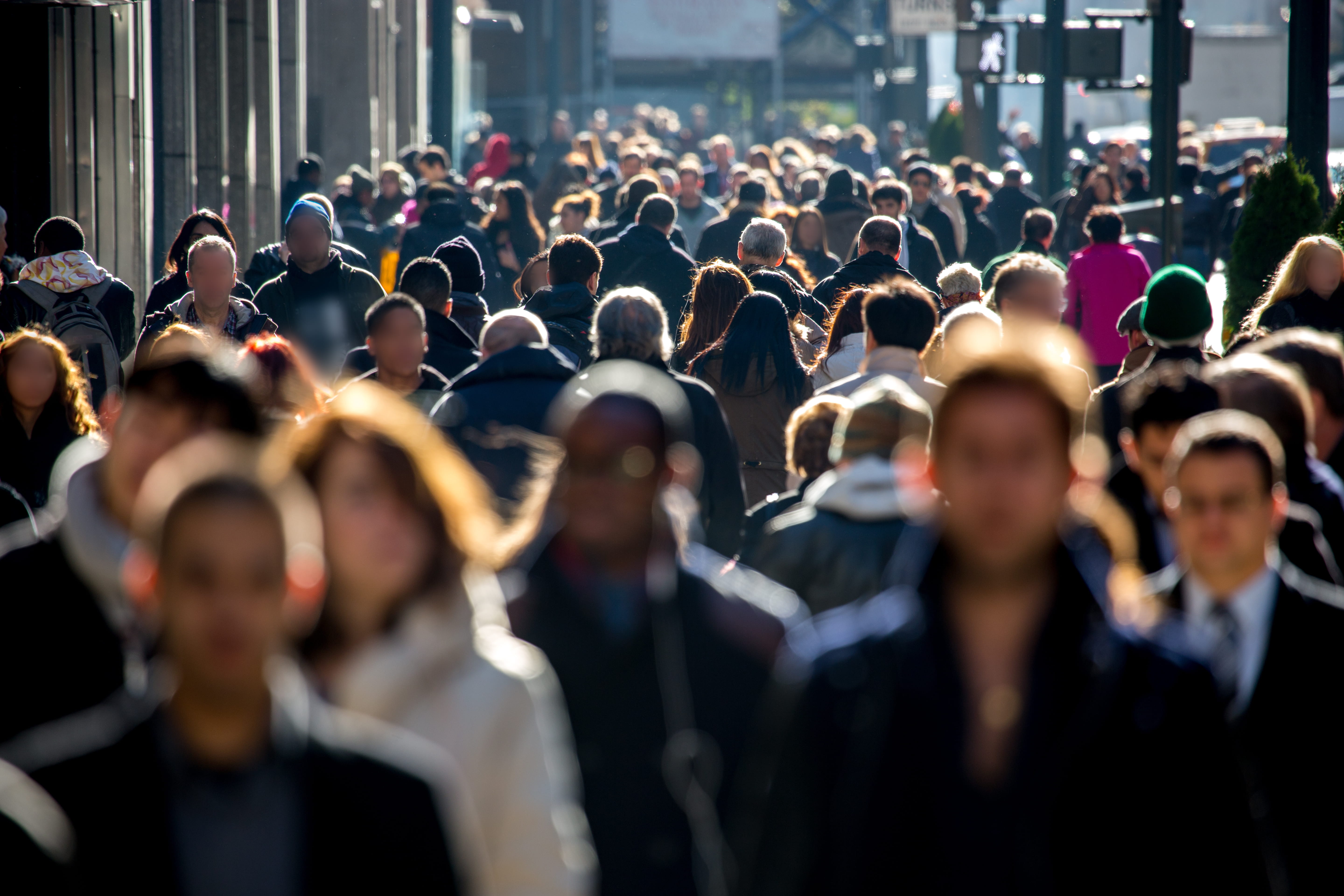 A crowd of people walking down a sidewalk