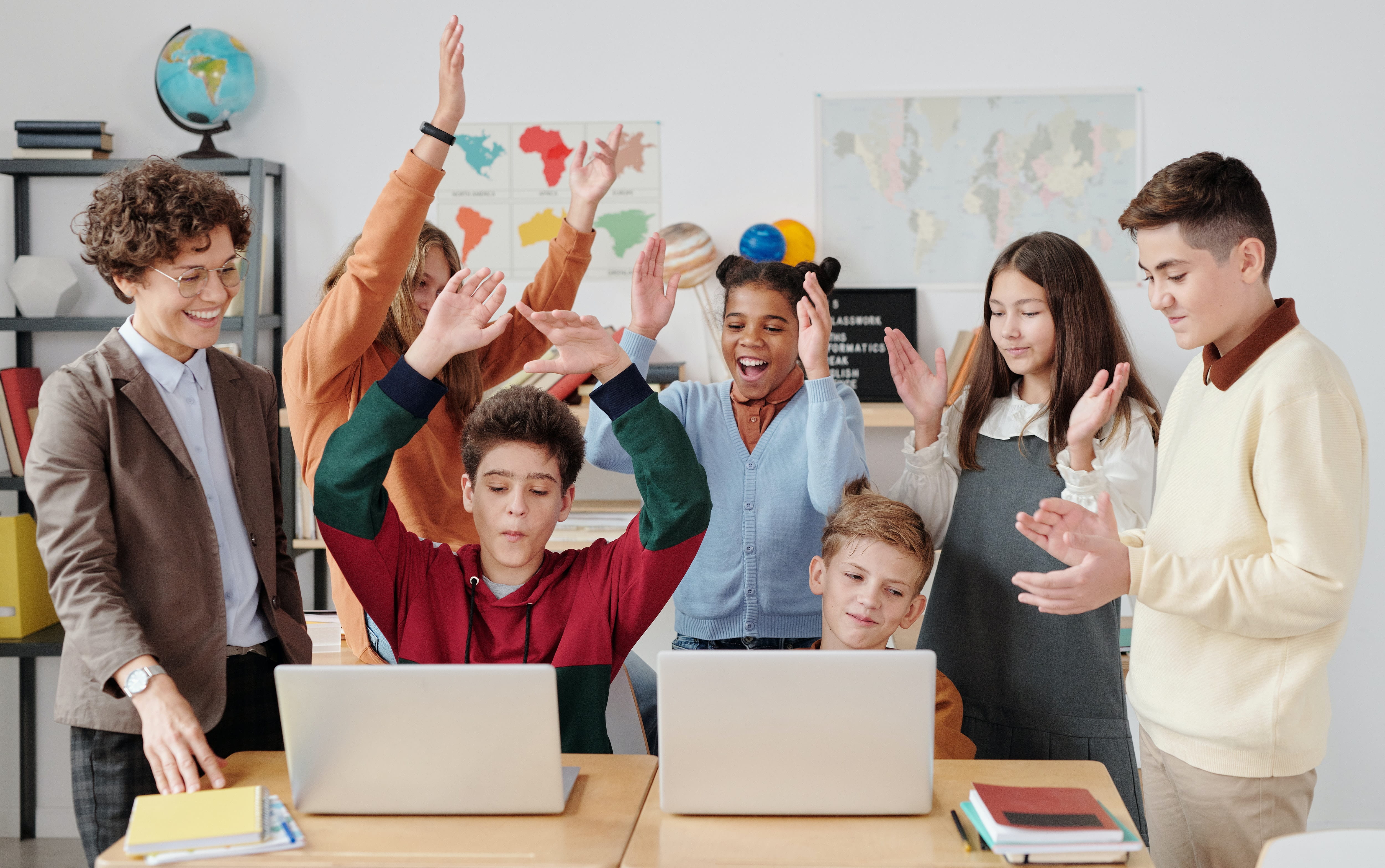 A teacher with her students around a table.