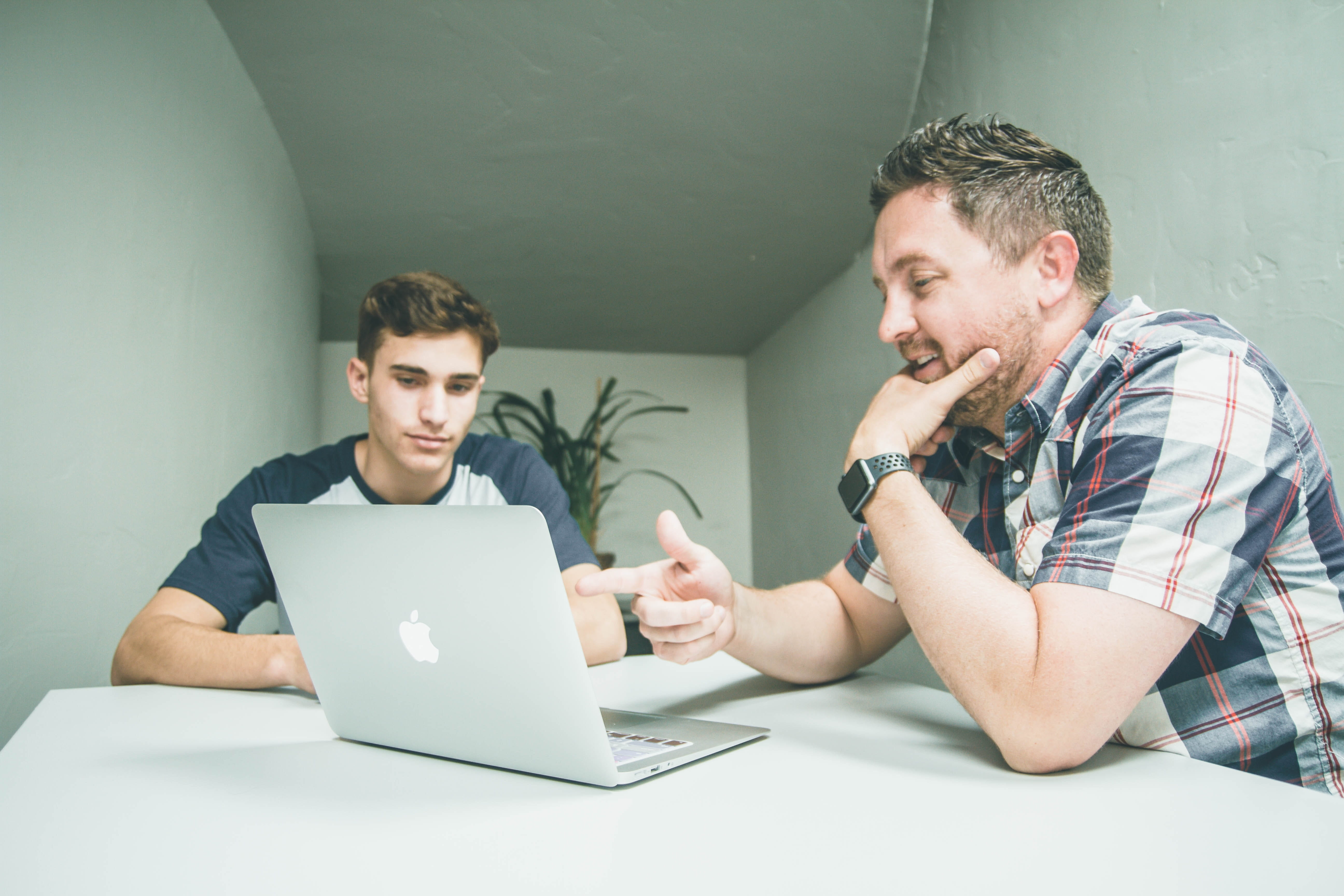 A parent with a student at a computer.