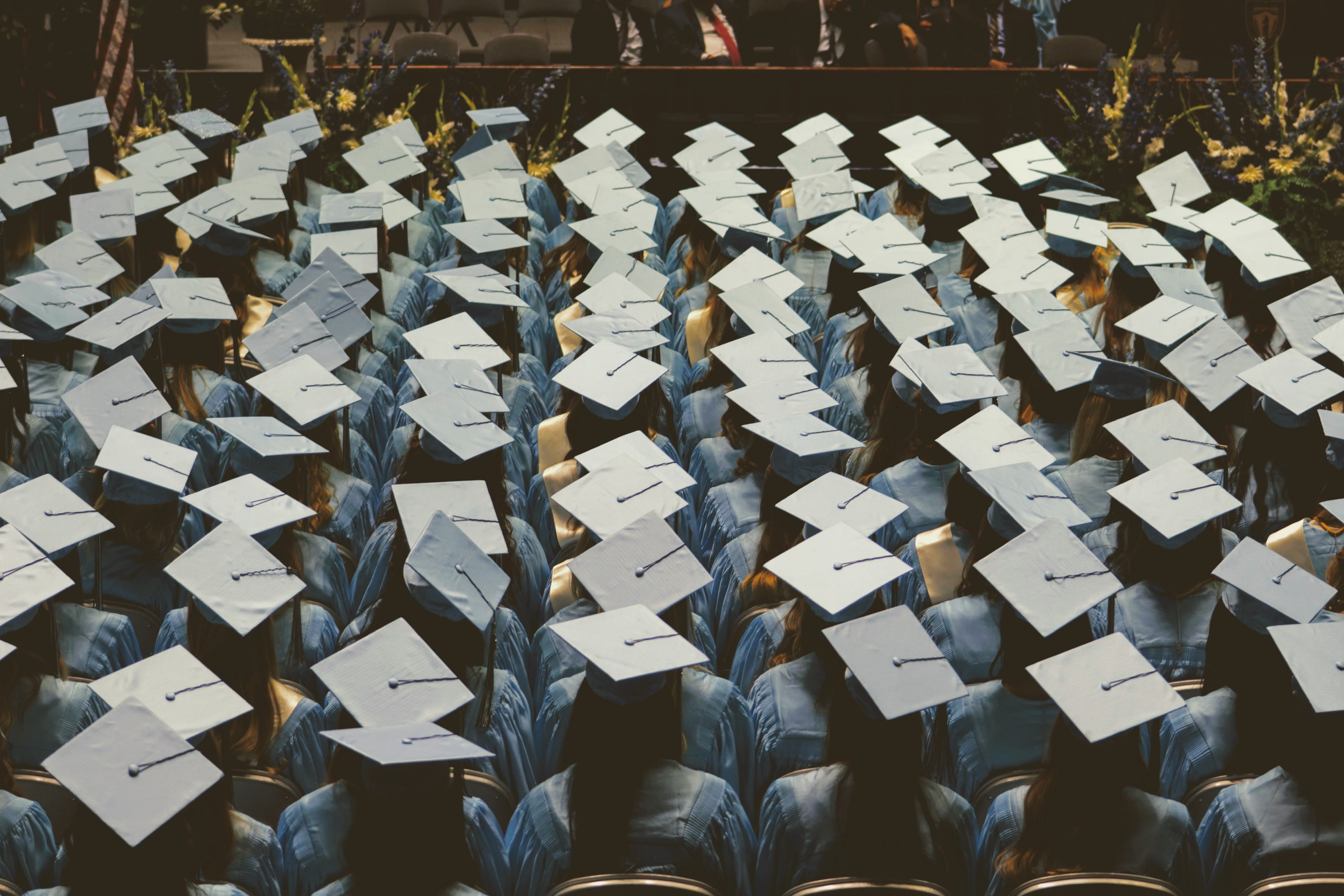 Graduates sitting in their chairs at a graduation ceremony.