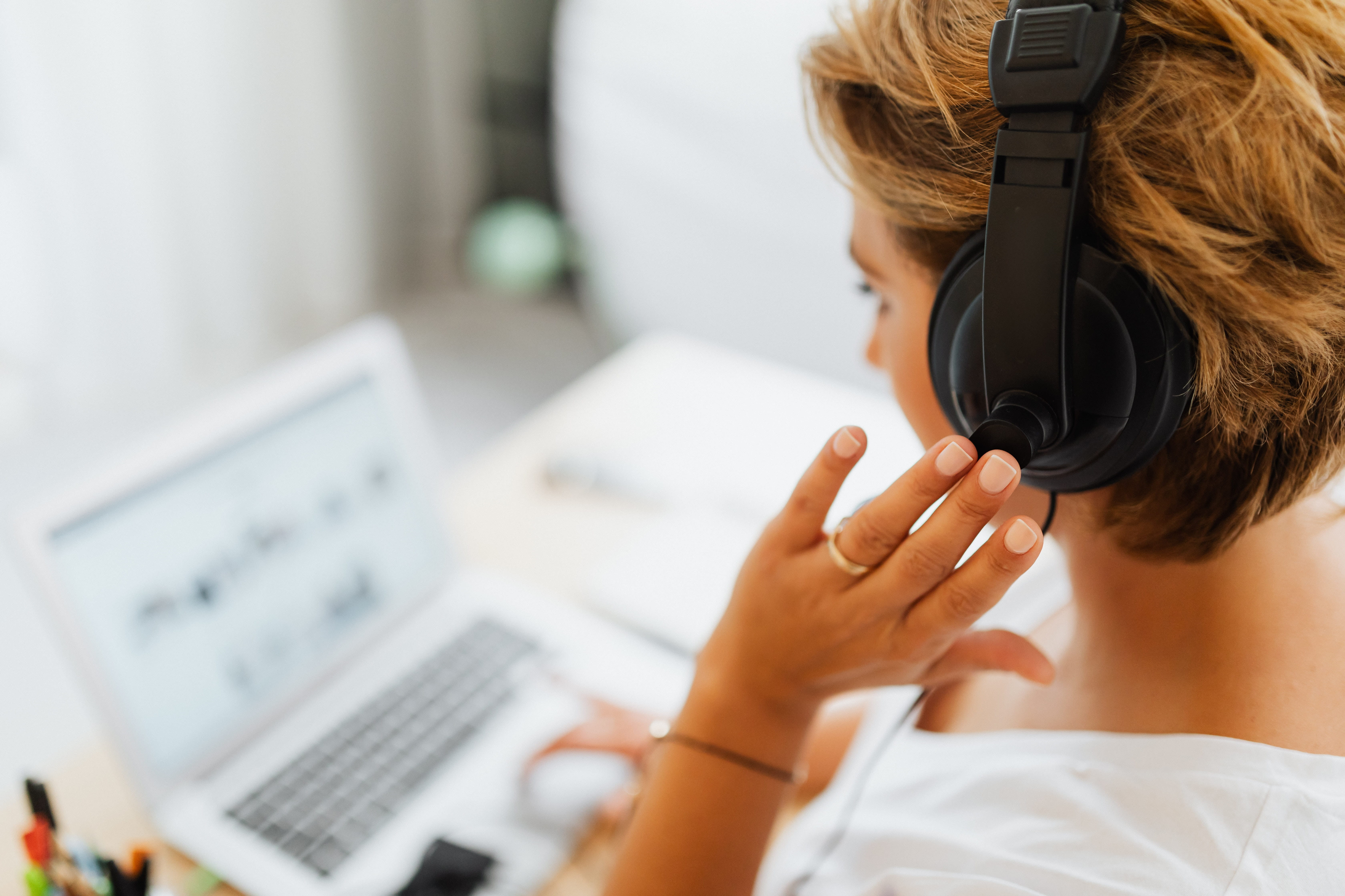 Someone at a computer with a headset.