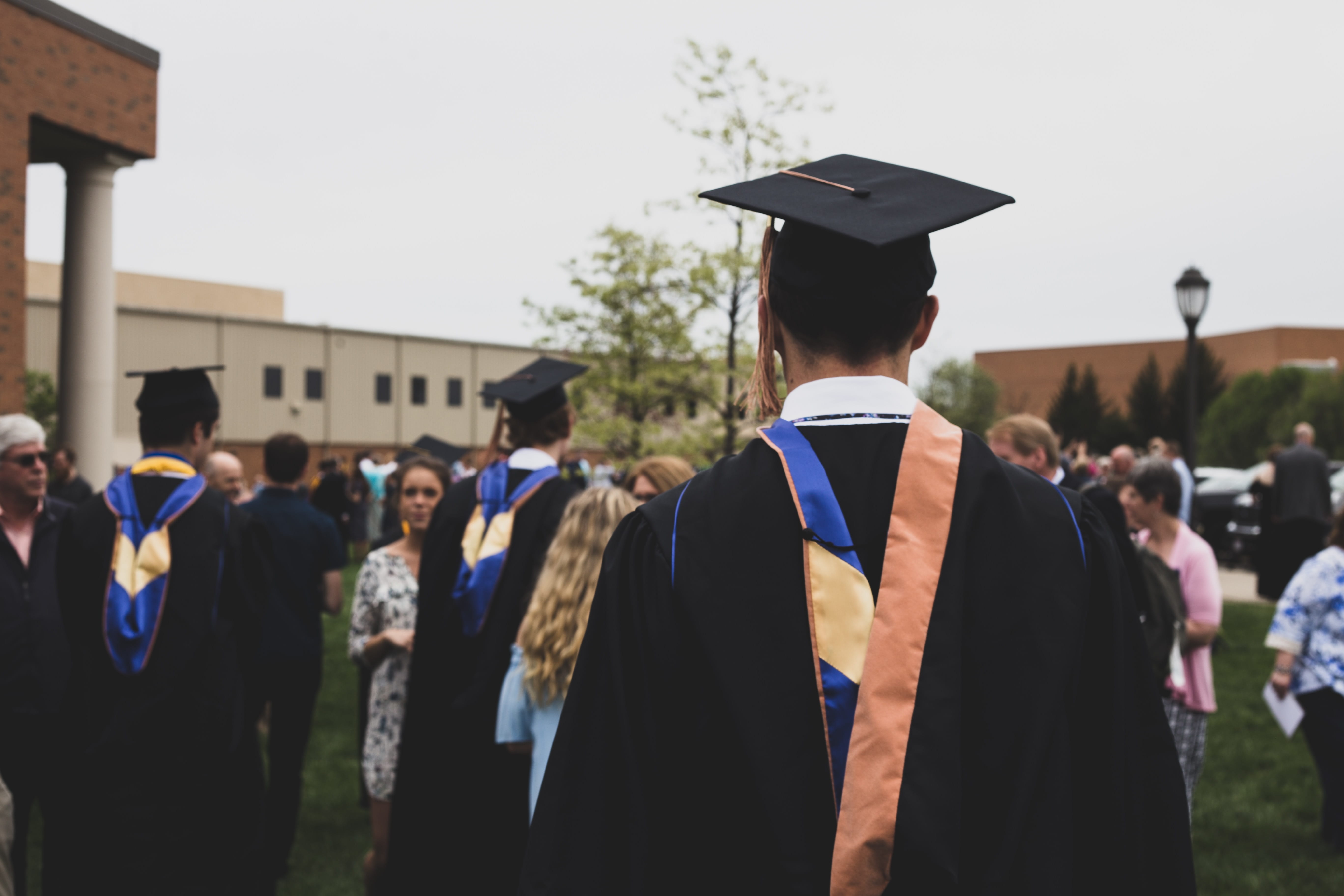 A college graduate wearing a graduation cap amongst other graduates.