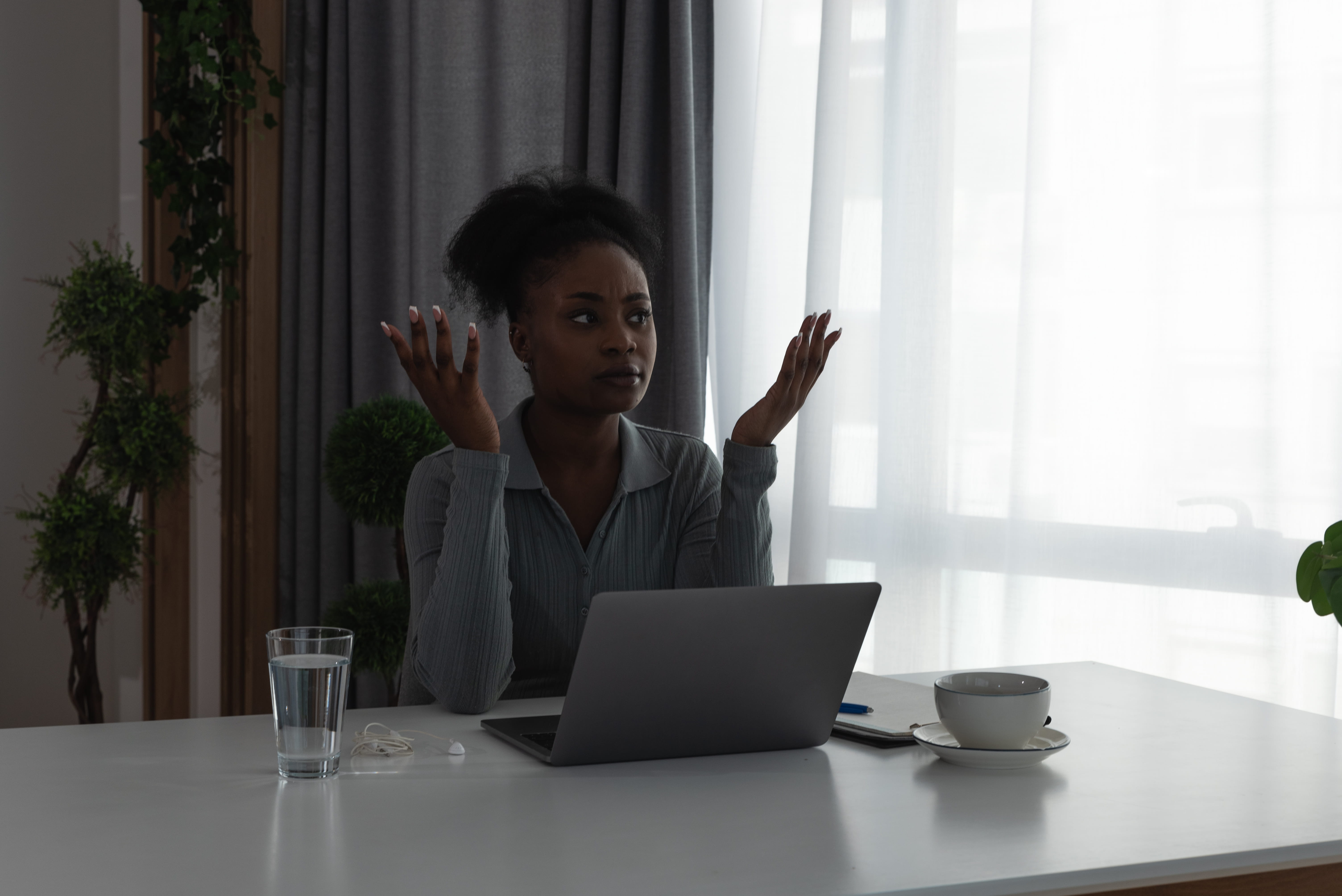 Young stressed and tired African American business woman working late feeling depressed angry and anxious after power outage in the office. Female worker overworked in the office on laptop computer