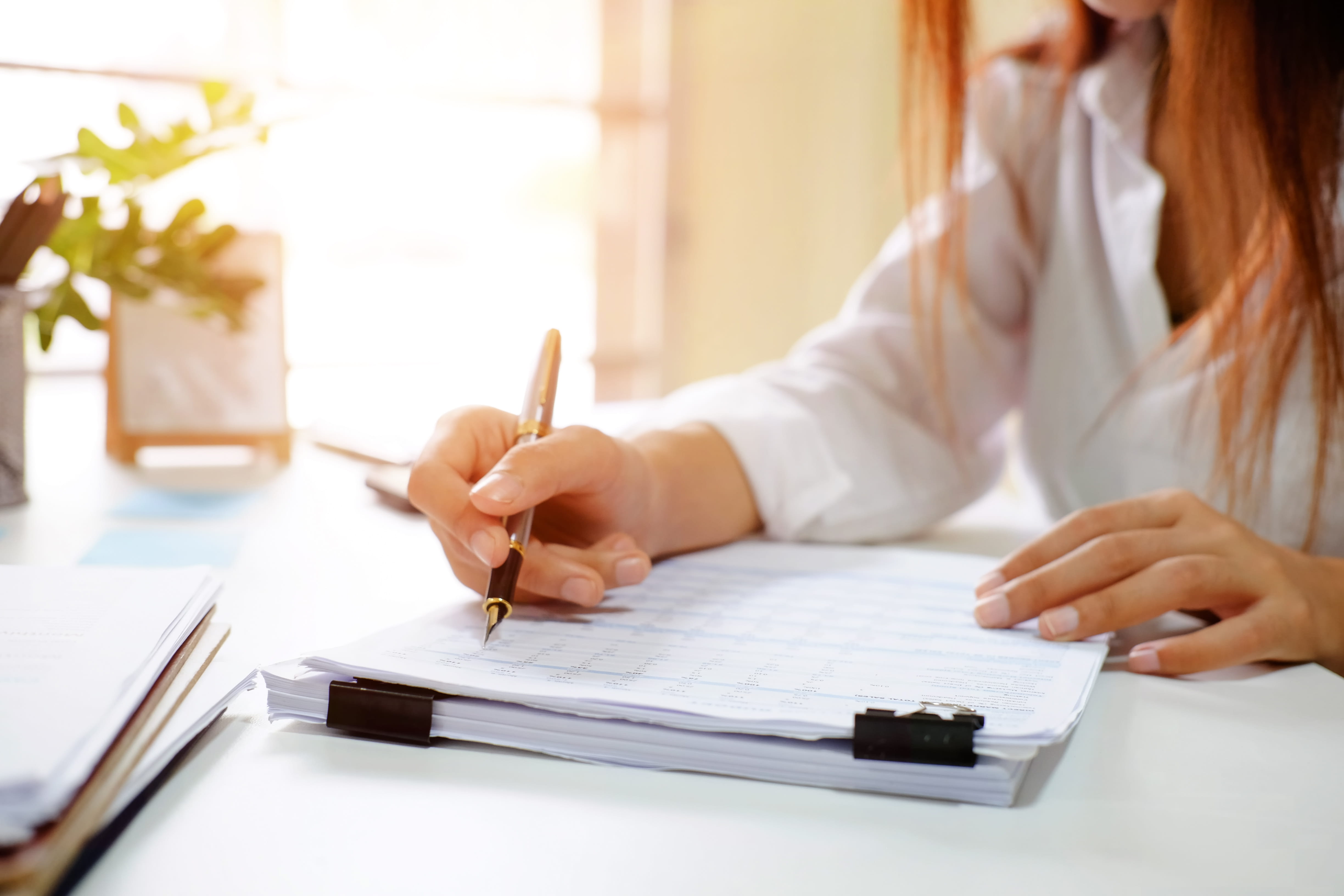 Close up audit woman calculate on paper document financial data.