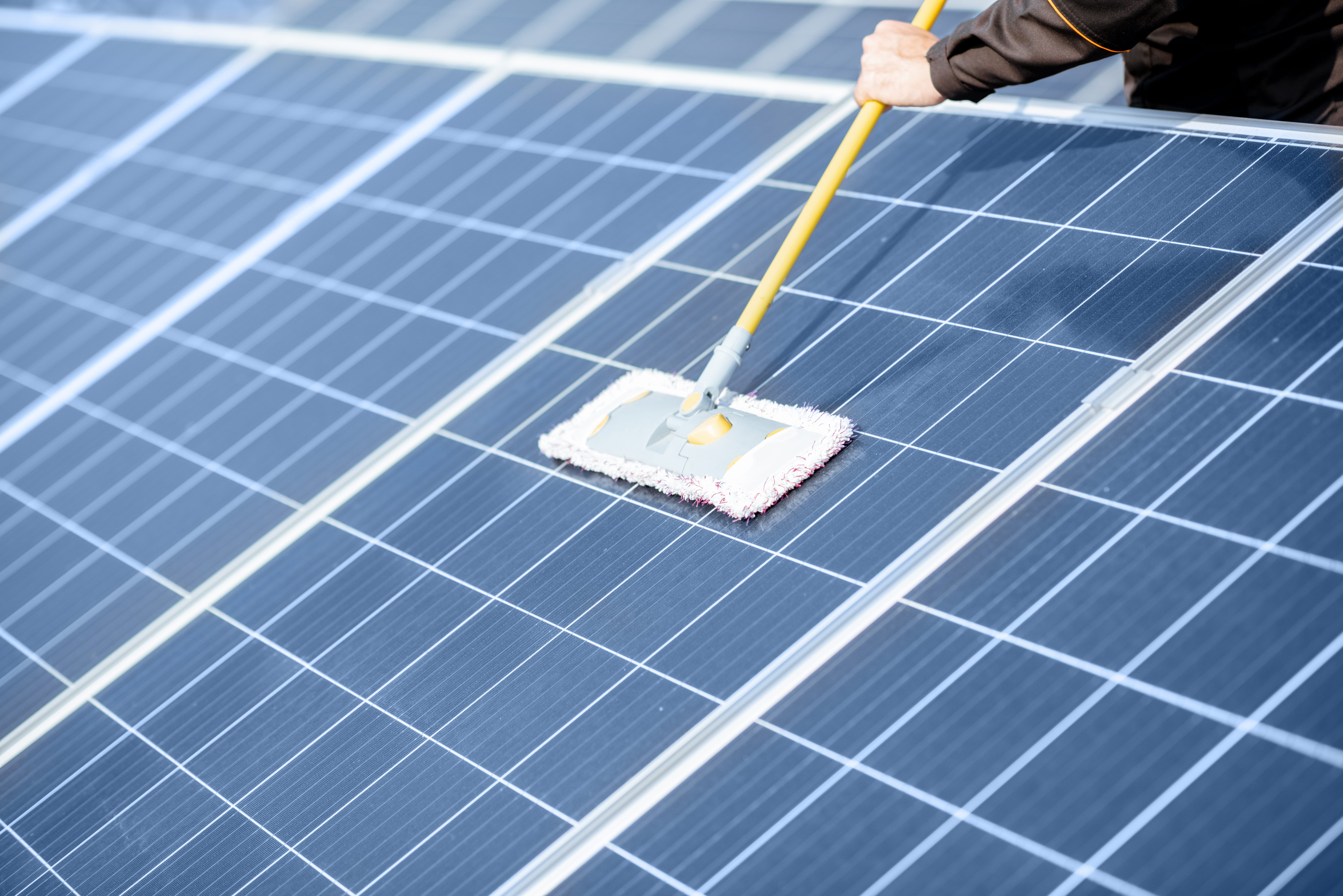 Workman cleaning solar panels