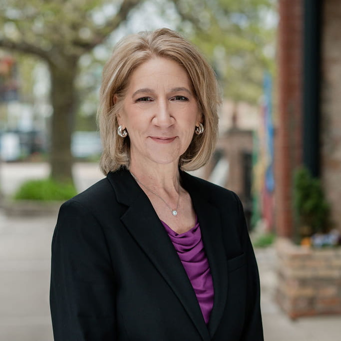 Woman wearing black blazer in a professional headshot pose