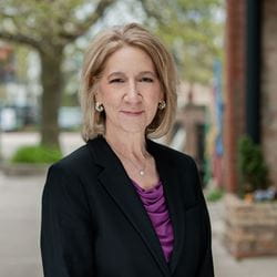 Woman wearing black blazer in a professional headshot pose