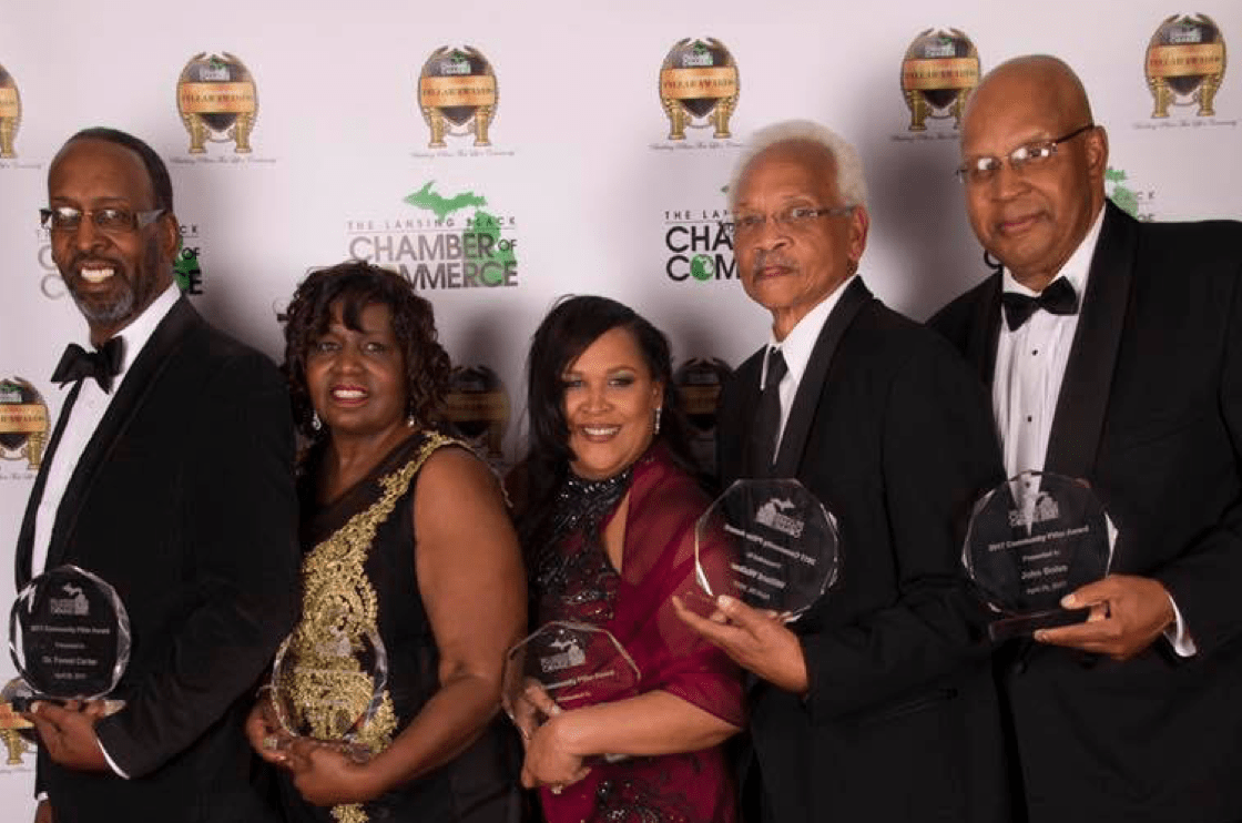 A group showing off their awards