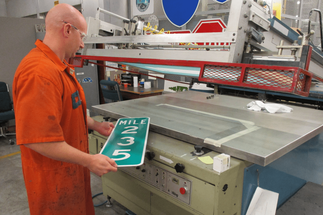 Man making a mile marker sign