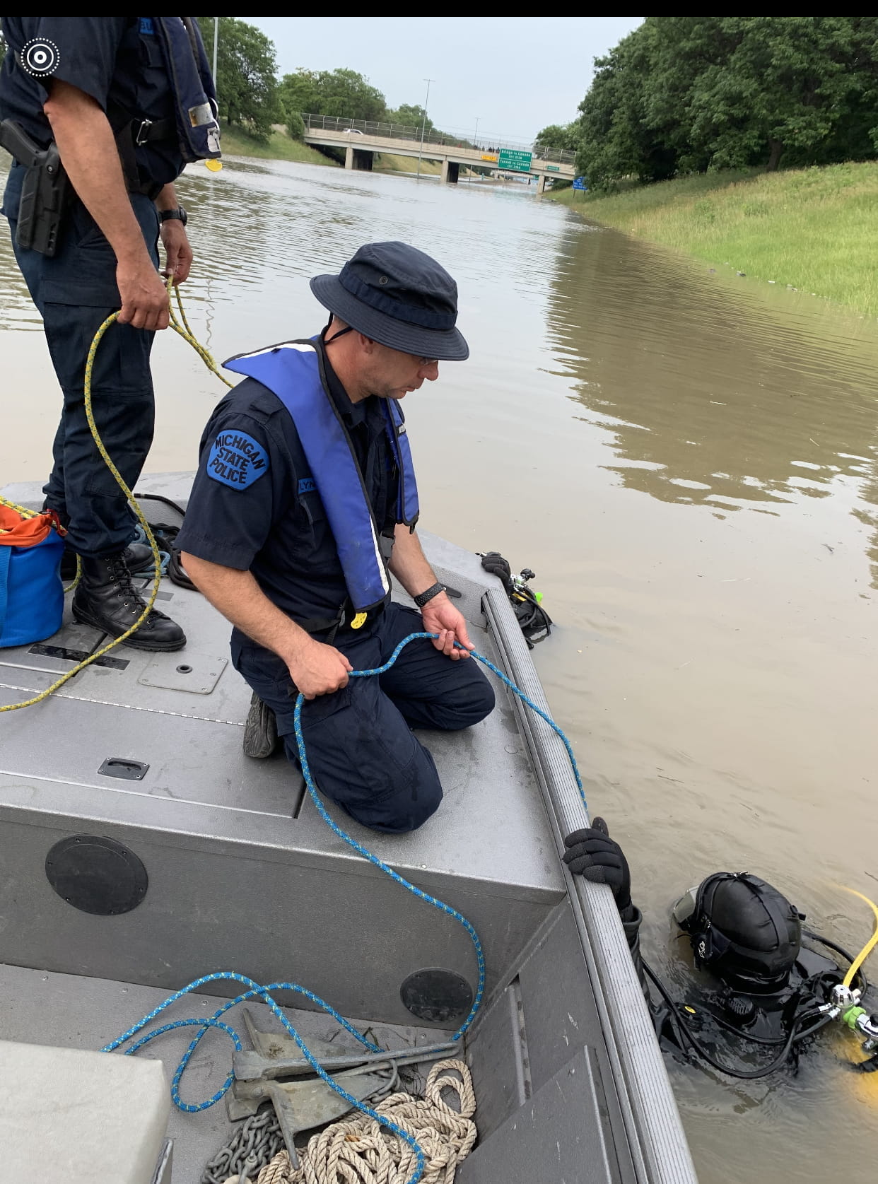Two troopers in a small boat in flood waters in SE Michigan.