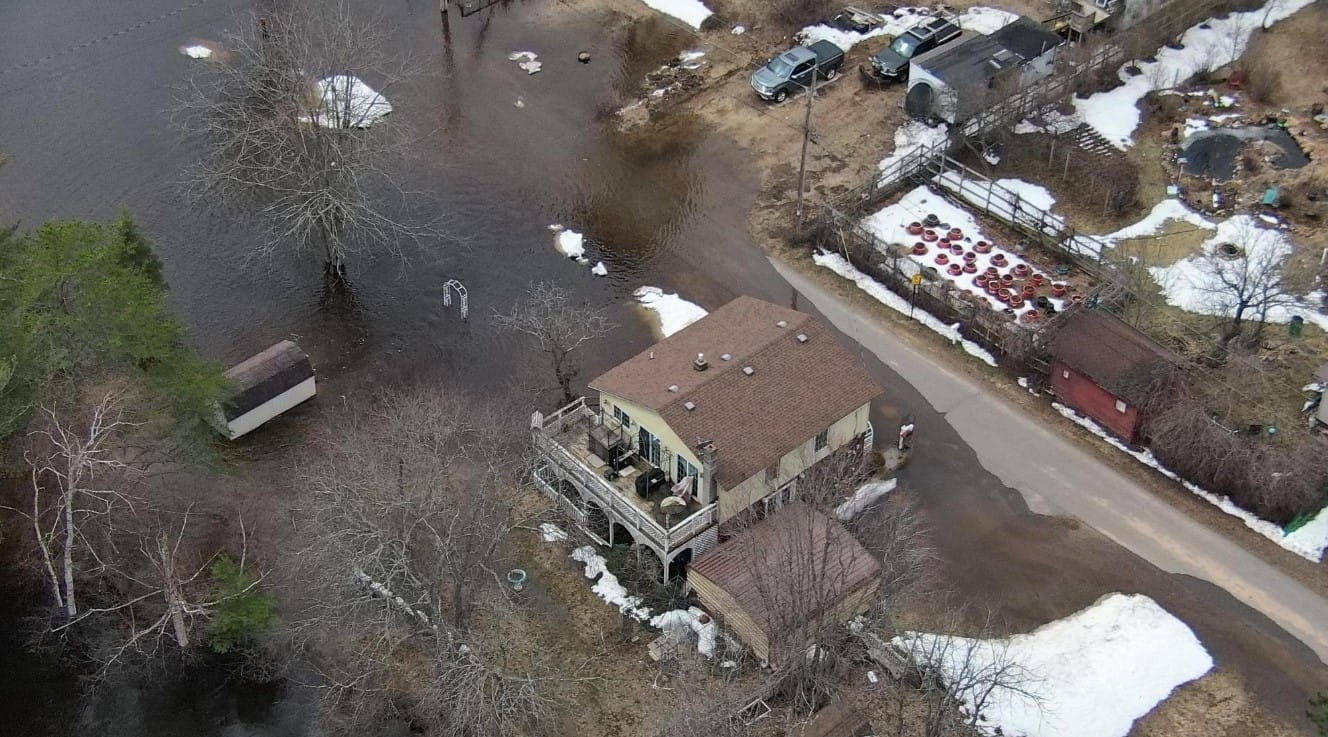 An aerial view of a house surrounded by flood water.