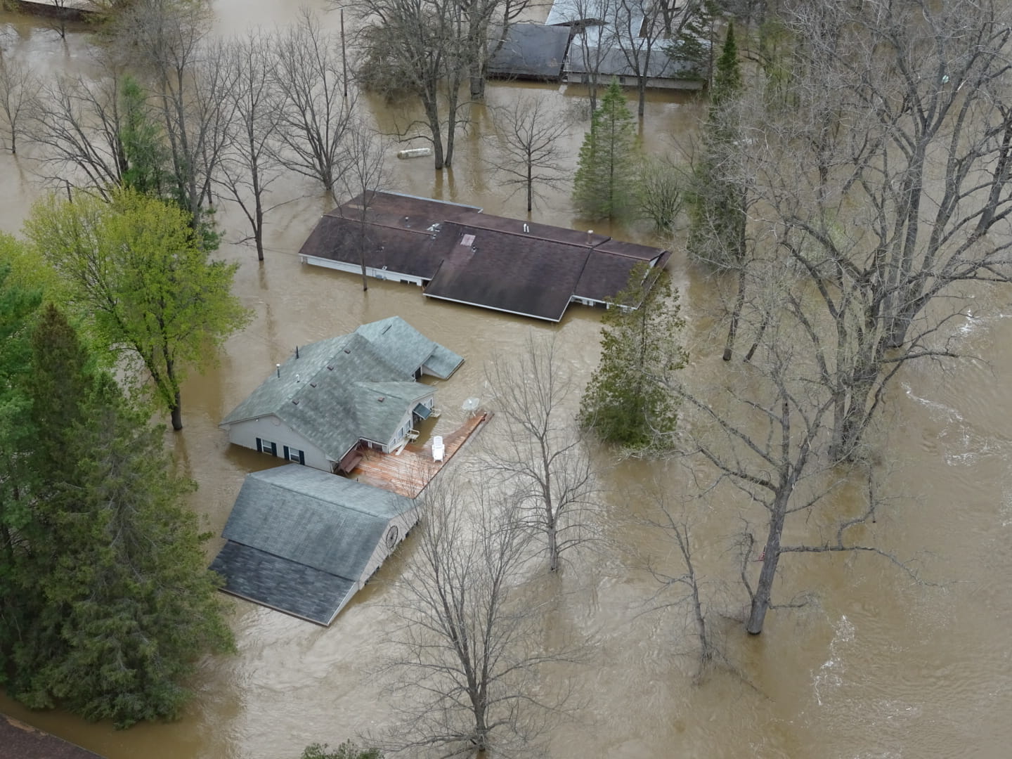 An aerial view of houses surrounded by flood water. 