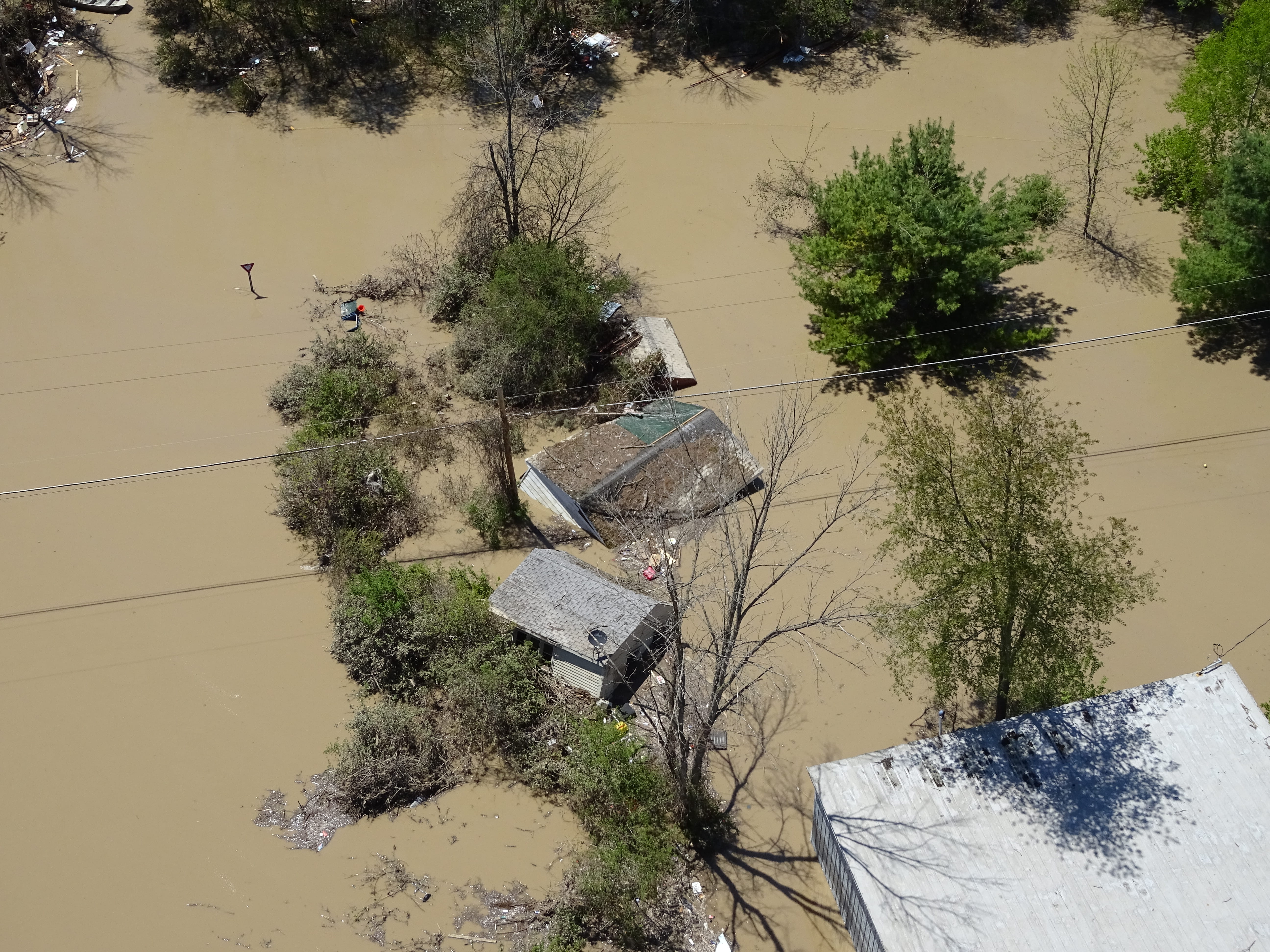 An aerial view of houses surrounded by flood water. 