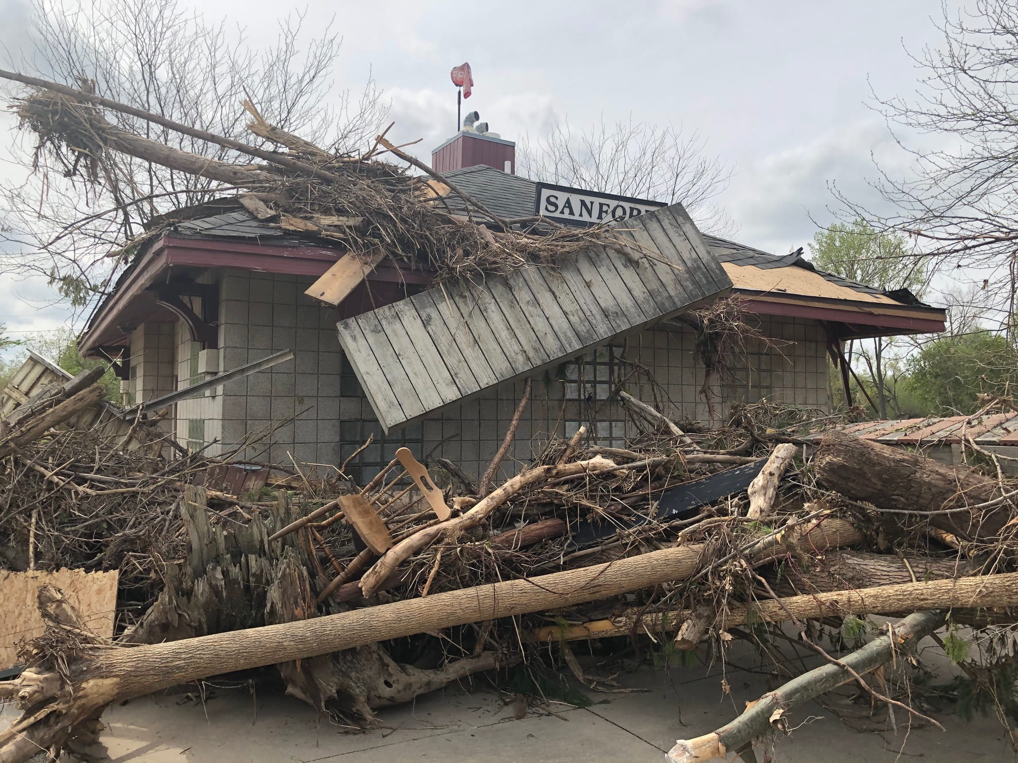 A damaged building surrounded by debris after a flood. 