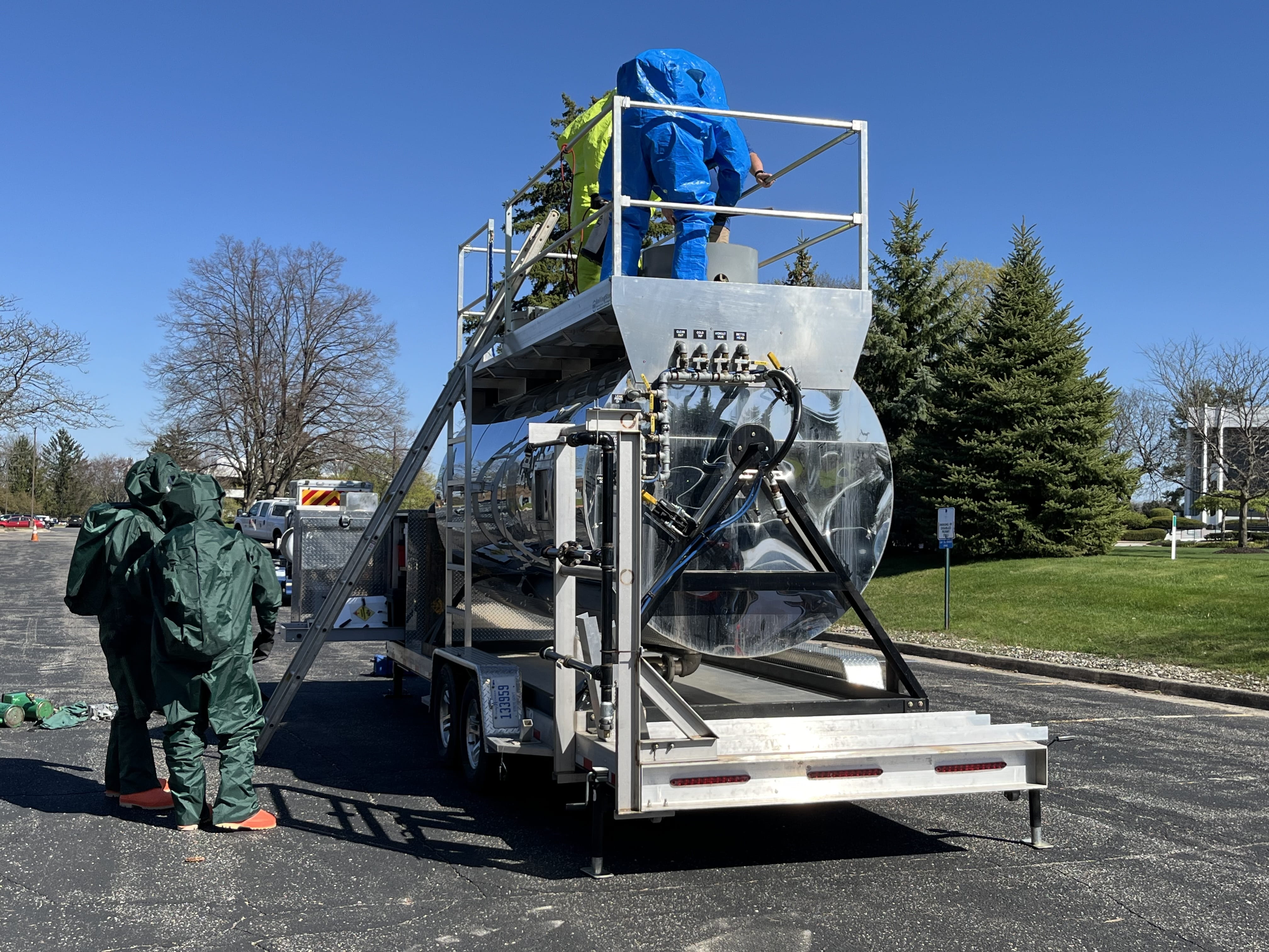 People in hazmat suits training on the portable hazmat tanker simulator.