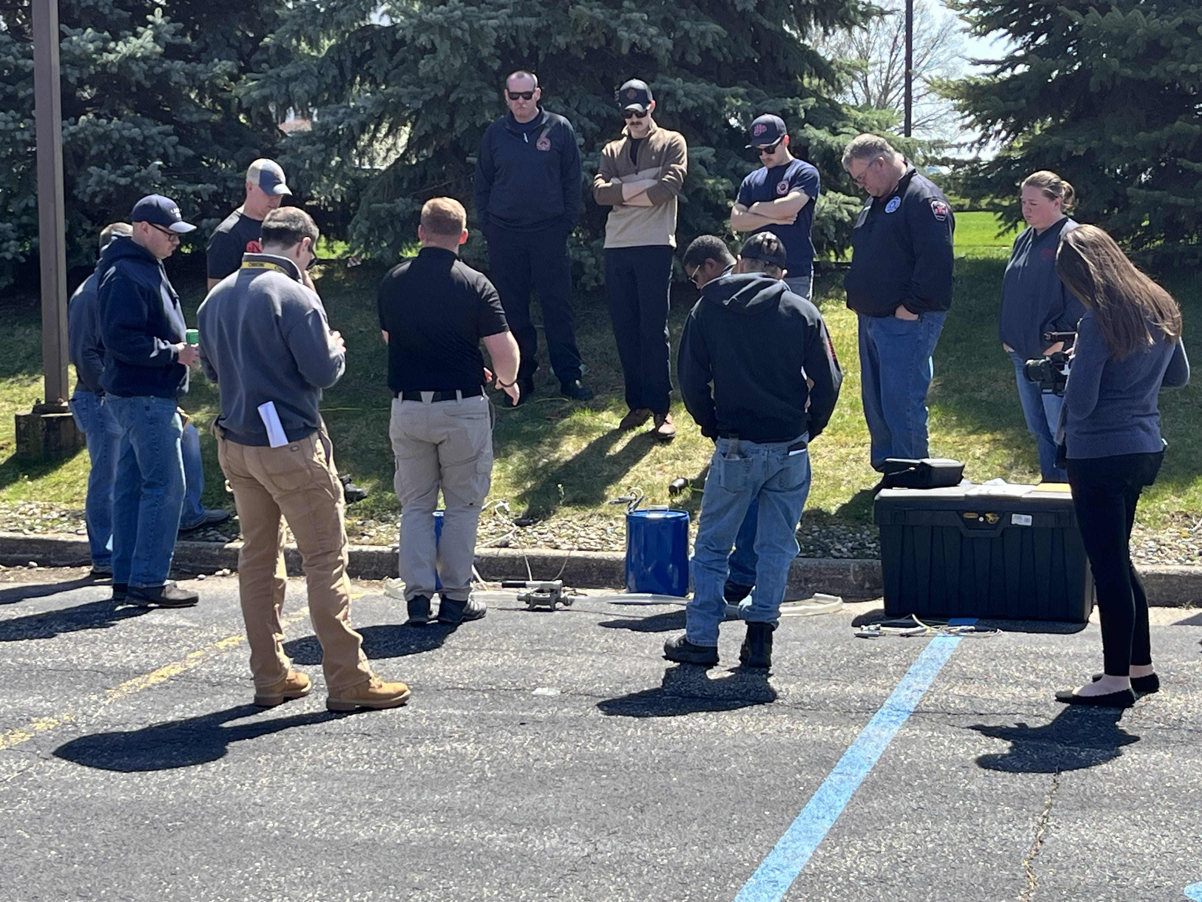 People gathered around an instructor outdoors at the Michigan Hazmat Responder Conference.