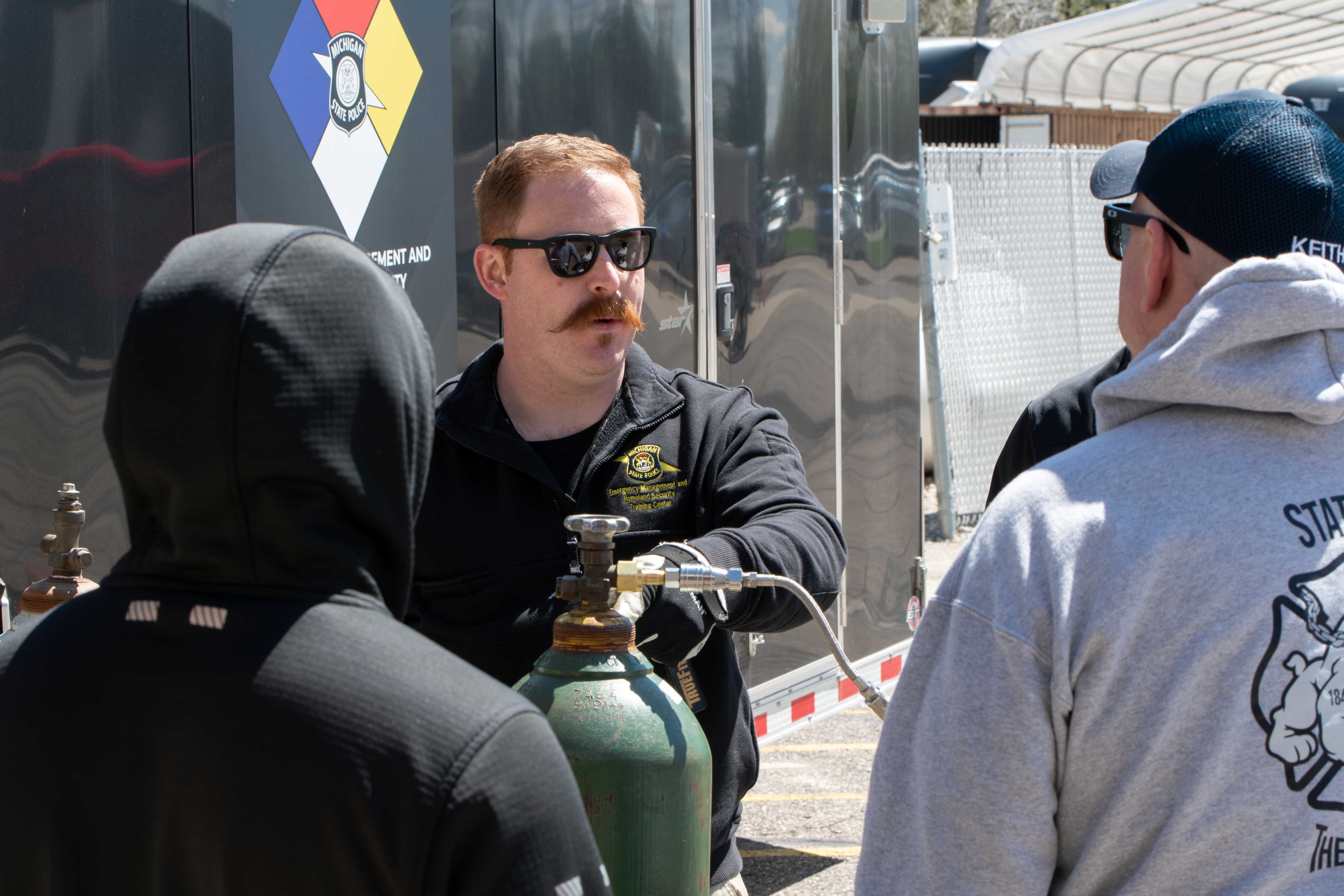 An instructor showing a demonstration outdoors at the MI Hazmat Responder Conference.