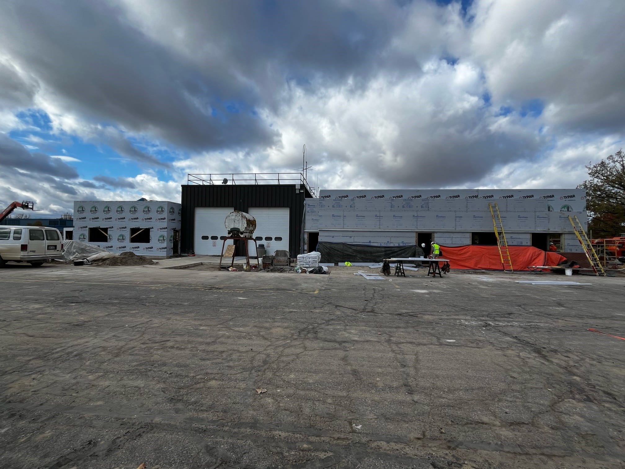 A view of the back of the building showing the newly built expansion to the right of the existing building and garage doors. 