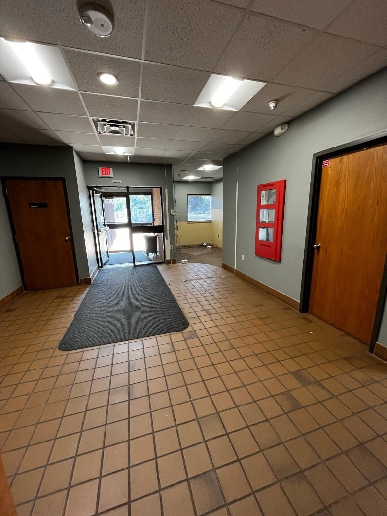 The empty lobby at the Hazmat Training Center with brown tiles and grey walls. 