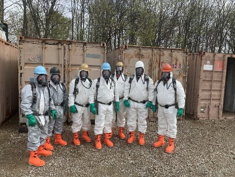 A group of people in hazmat suits at the Hazmat Training Center. 