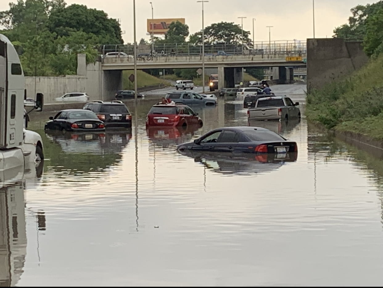 Cars stuck in flood water underneath an overpass.