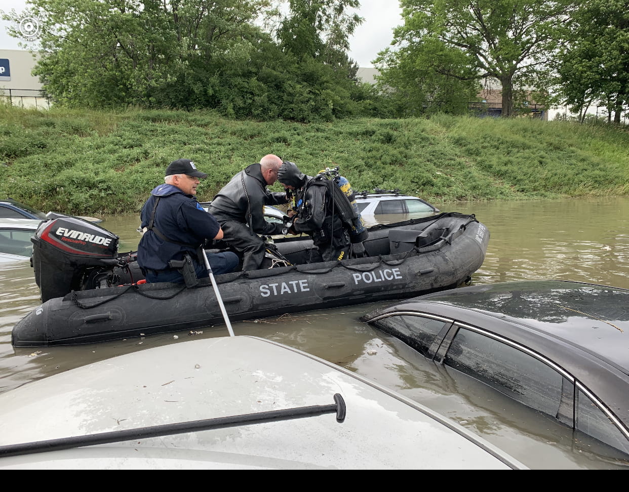 Two MSP Troopers on a small boat in flood waters.