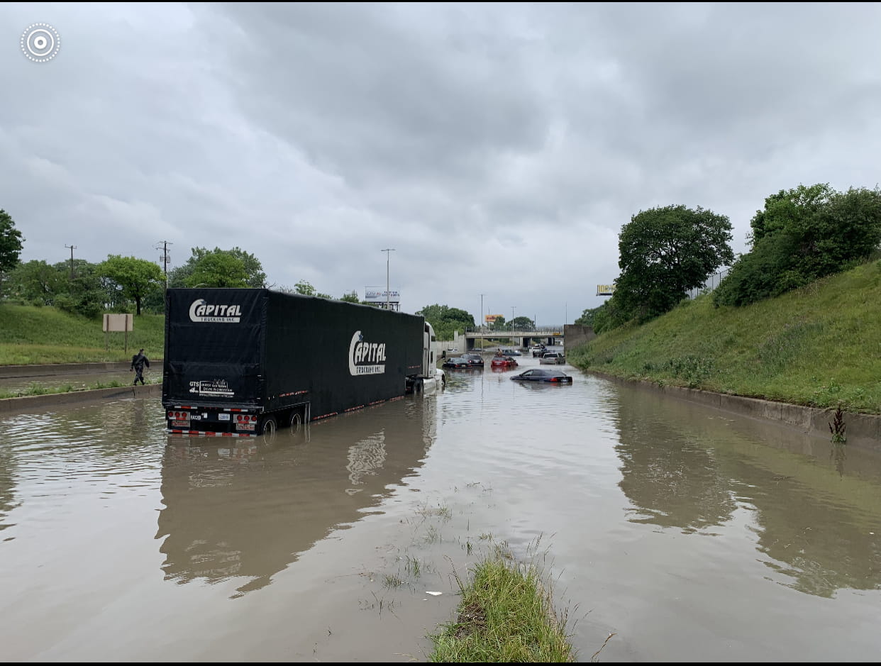 A semi and several cars stuck in flood water. 