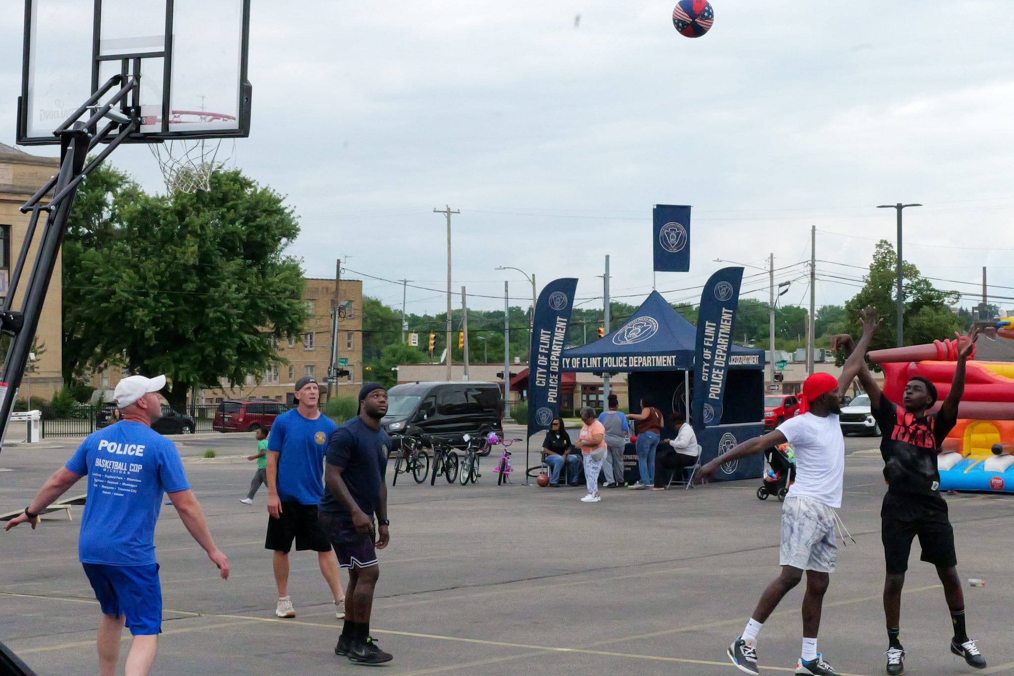 Police officers and community members playing basketball. 