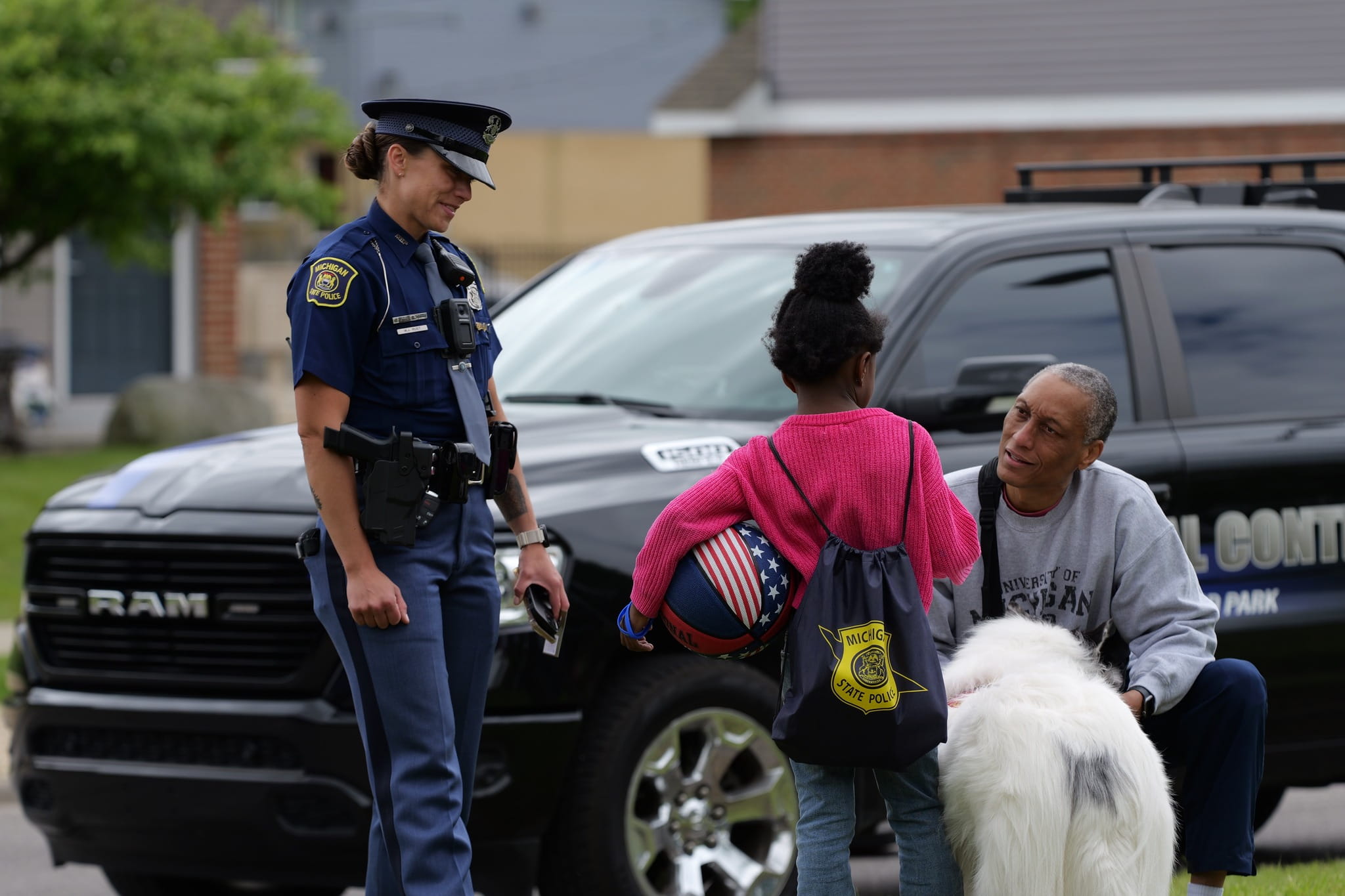 Female MSP trooper speaking with a young girl and her father. 