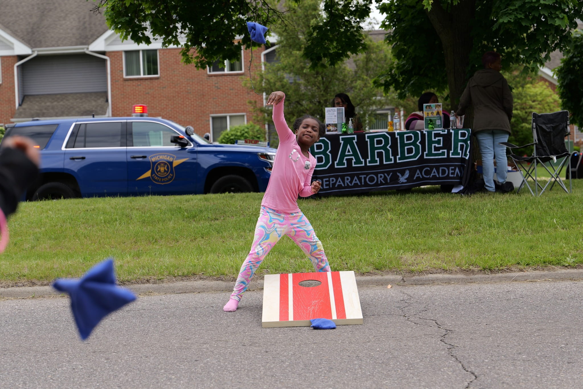Young girl playing cornhole. 