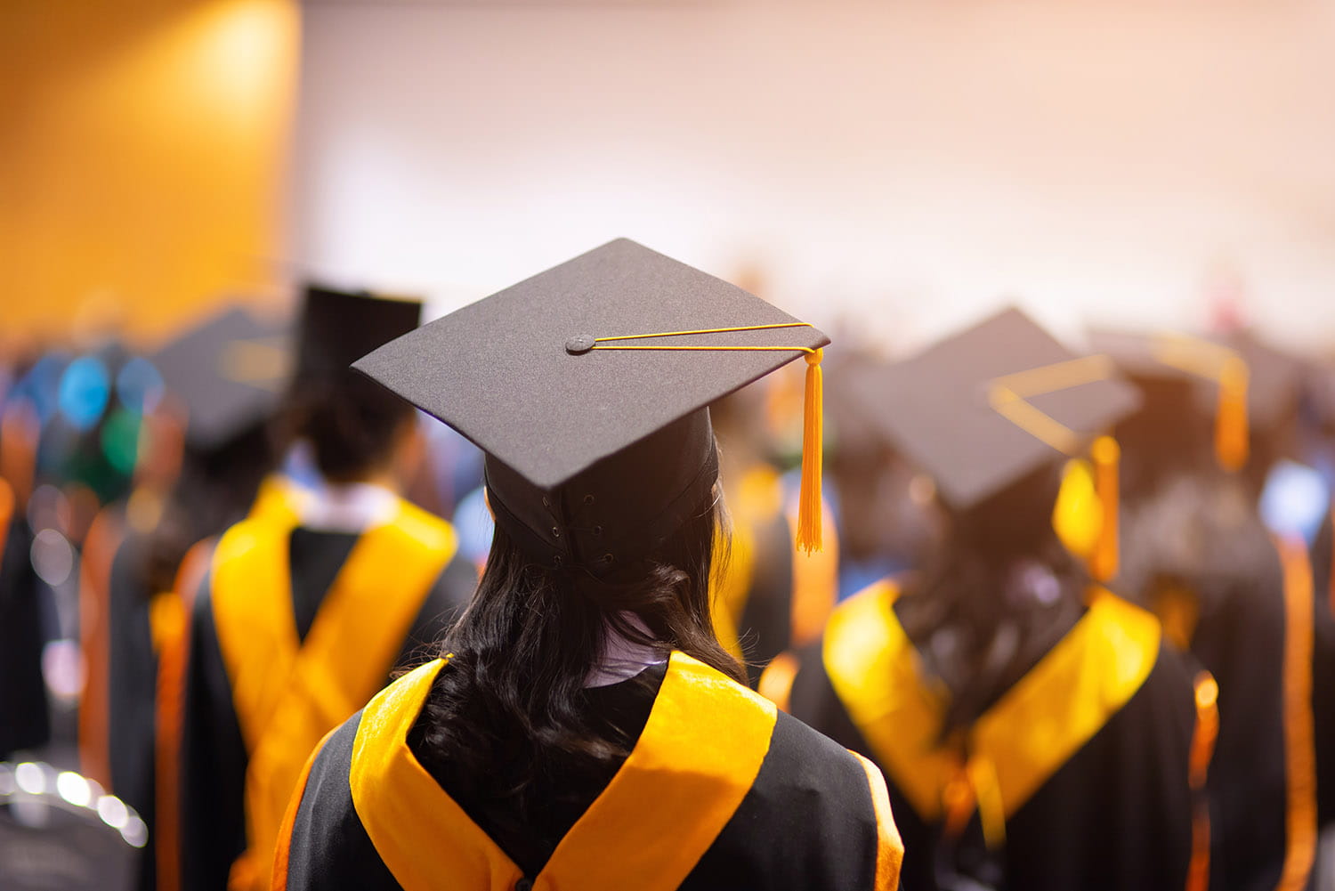 College Students in black robes with a yellow sash.