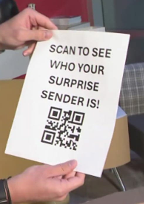 Hands holding a piece of paper that says *Scan to see who your surprise sender is!* followed by a QR code.