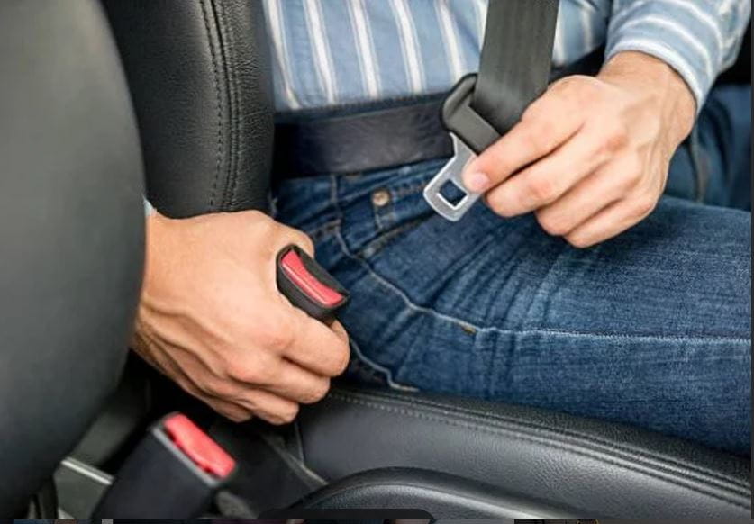 man buckling seat belt