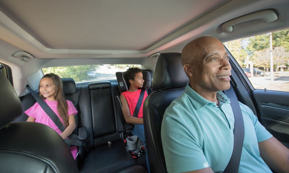 family riding in vehicle with all wearing seat belts