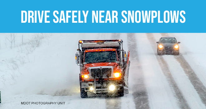 Car driving near snowplow on snowy road