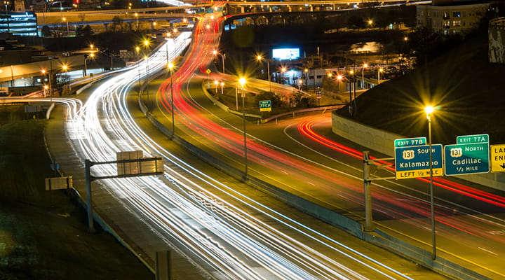 Time-lapse with vehicle lights on road at night. 
