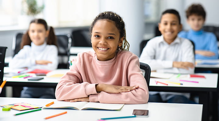 School children sitting at desks in classroom. 