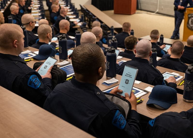 Trooper recruits sitting in auditorium. 