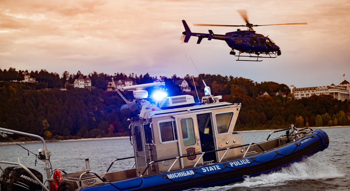Michigan State Police Marine Services boat and helicopter of the coast of Mackinac Island. 