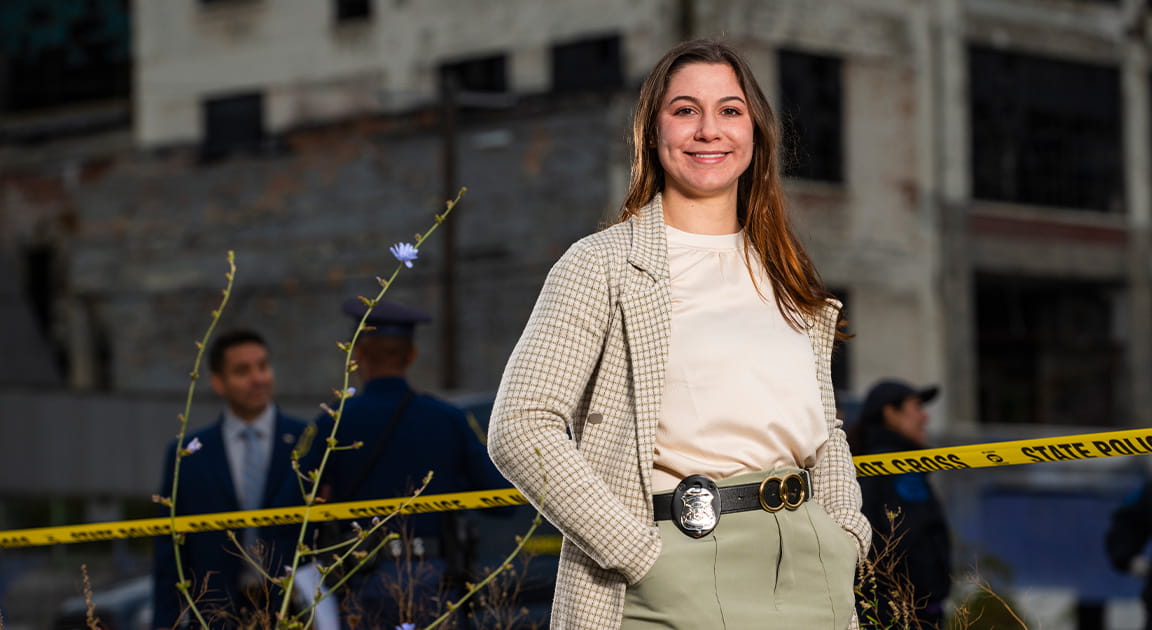 Female Michigan State Police detective with badge on belt.