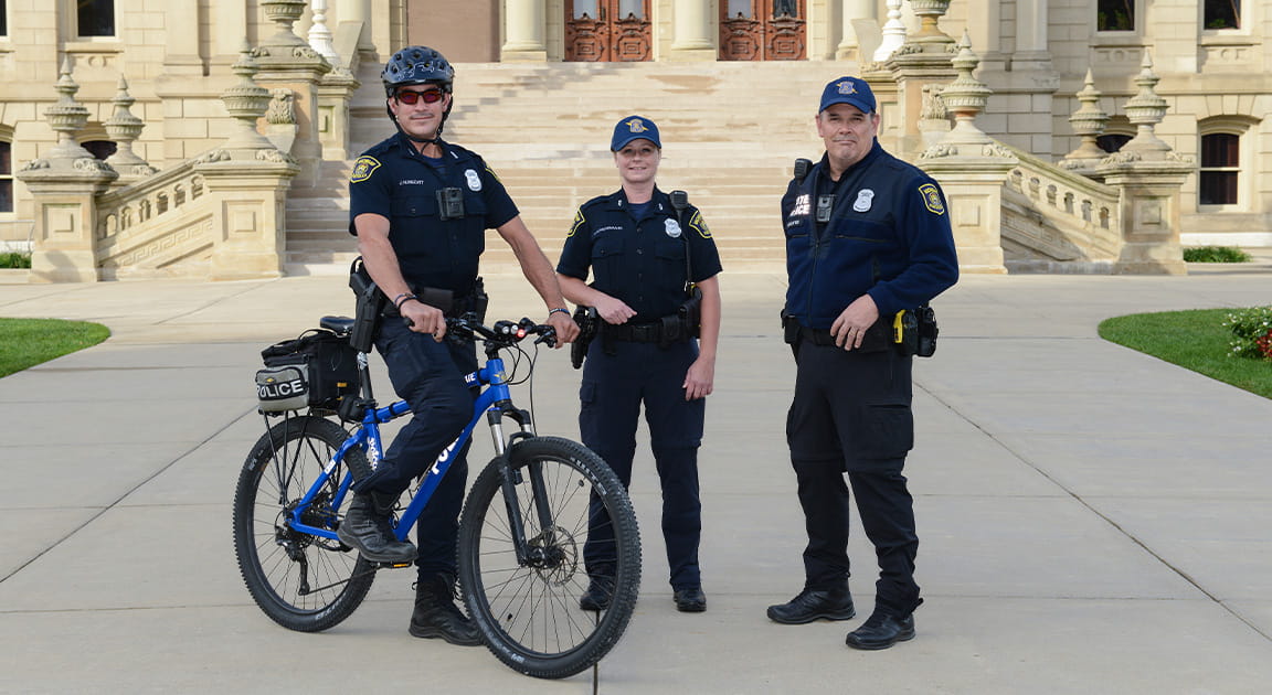 Three state properties security officers in front of the State Capitol. 