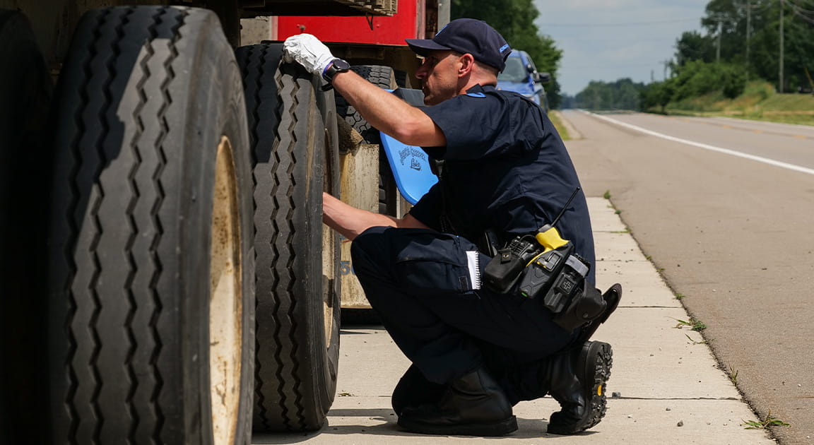 Motor carrier officer inspecting a commercial vehicle. 